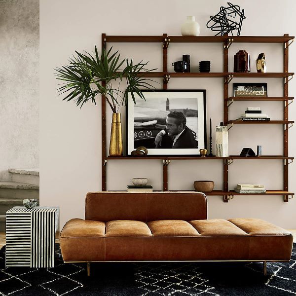 large floating shelf unit behind a couch styled with decor